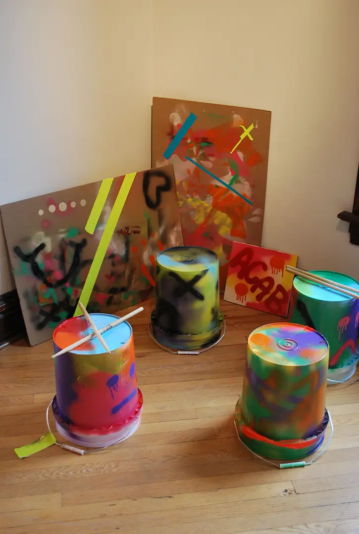 Collection of buckets in a corner with drumsticks.